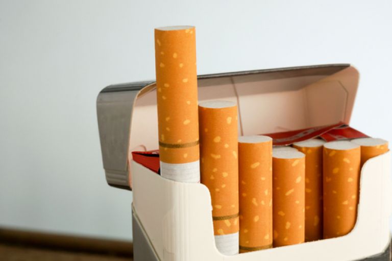 An image of a pack of cigarettes in an open packet. There is one missing and the first two are sticking out the box